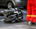 Crashed motorcycle after road accident with a car on a city street