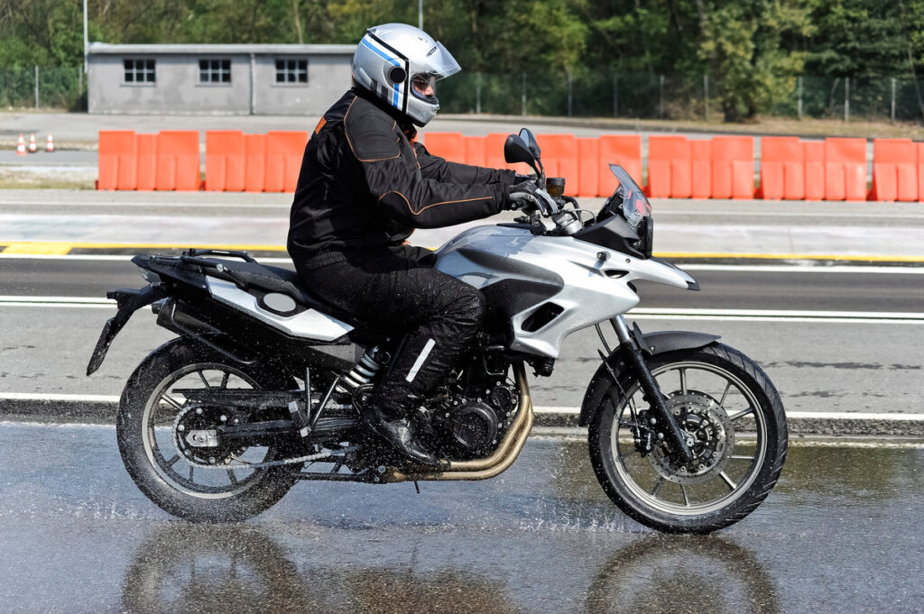 biker on road with helmet and wet asphalt
