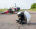 Photo of helmet and motorcycle on road, the concept of road accidents