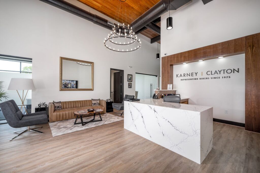 Karney Clayton law office reception area with marble desk, tan leather sofa, and wood ceiling
