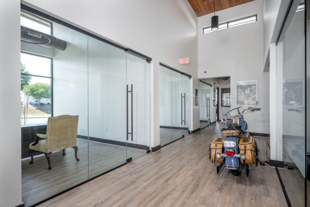 Karney Clayton office hallway with glass partition walls and motorcycle display